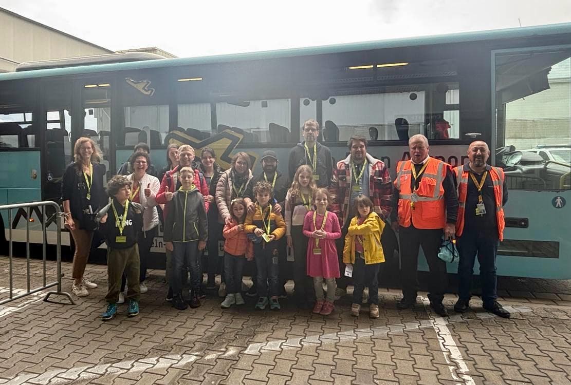 Gruppenausflug zum Flughafen vor einem Vorfeldbus.