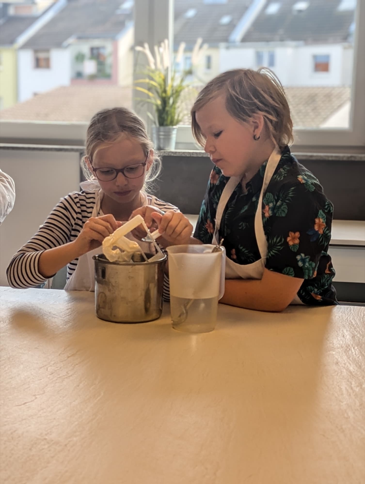 Zwei Kinder bereiten gemeinsam Eis zu.
