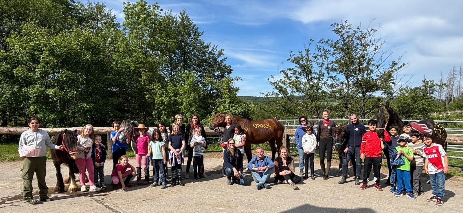 Kinder und ihre Begleiterinnen und Begleiter gemeinsam bei der Reiterfreizeit