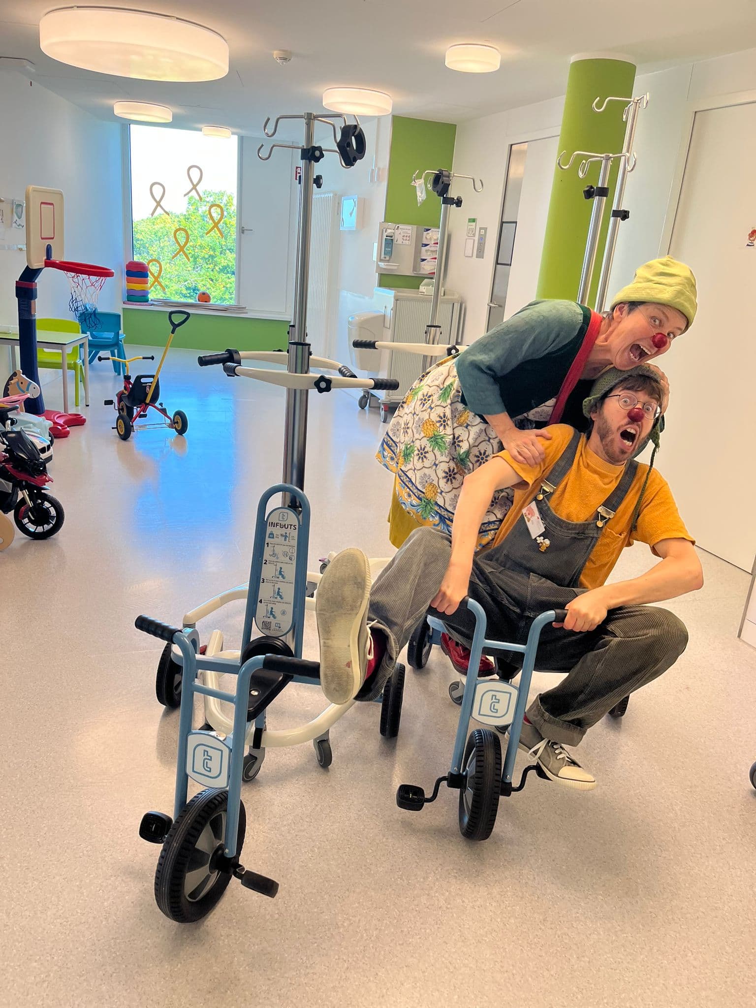 Die Klinik-Clowns testen die INFUUTS-Räder mit integriertem Infusionsständer.