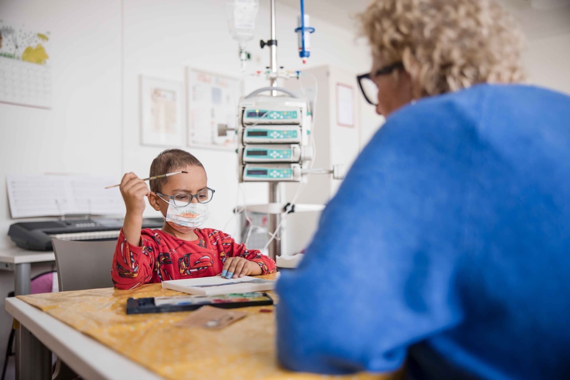 Ein Kind malt während des Klinikaufenthalts mit Wasserfarben.