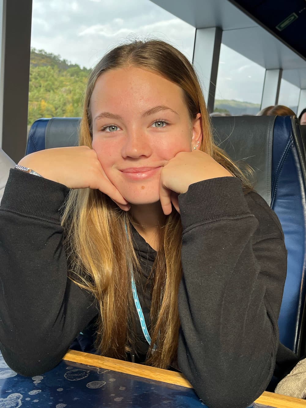 Carolin lächelt auf einer Zugfahrt in die Kamera